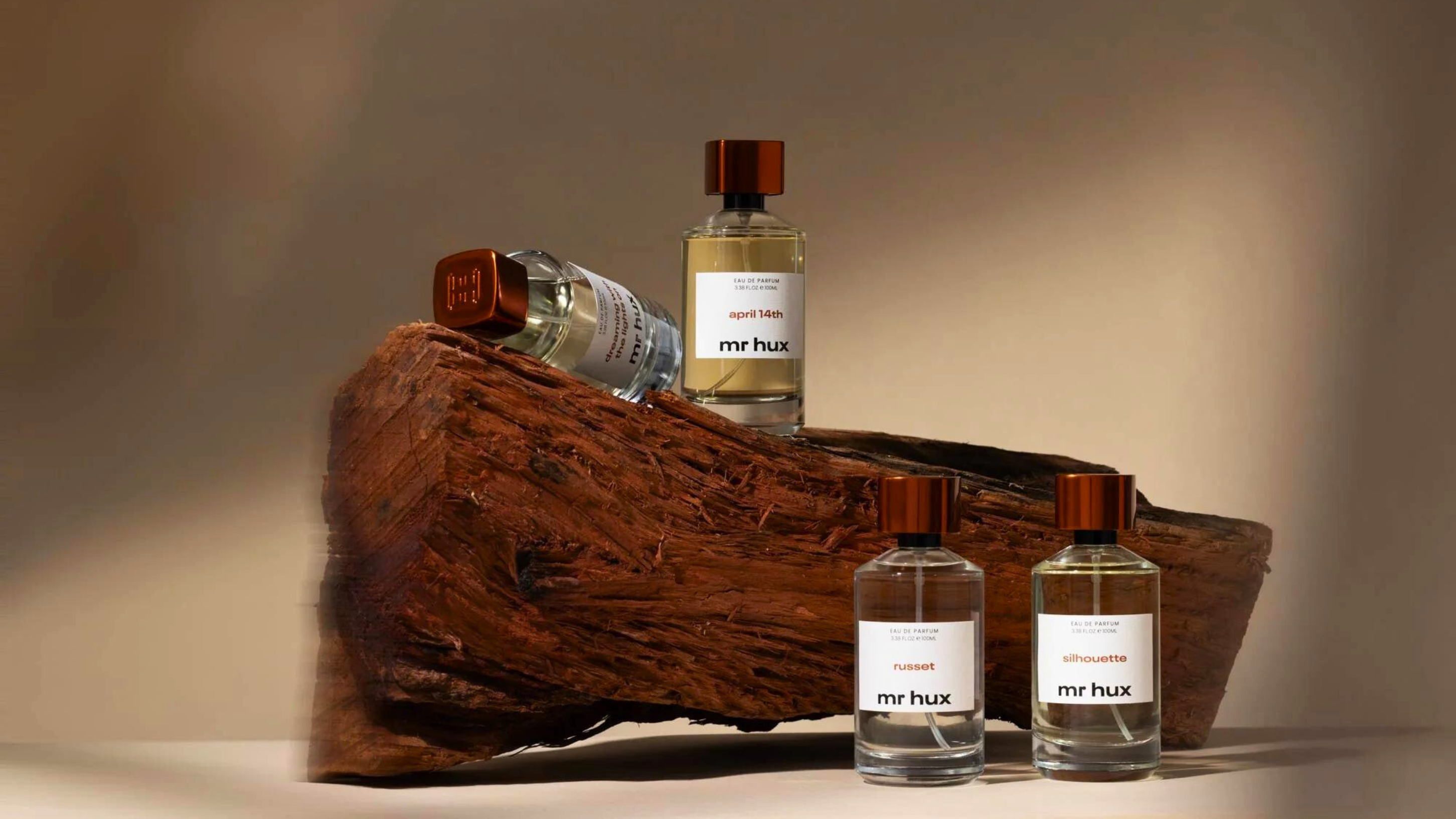 Main collection of Mr Hux fragrances, luxury perfumes on a wooden log